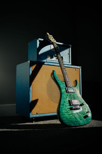A vertical shot of a green electric guitar