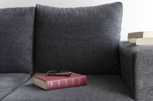 A book and glasses on the sofa