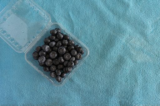 A high angle shot of blueberries in a plastic box