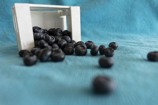 A selective focus shot of blueberries in a wooden box