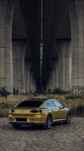 A vertical shot of a Volkswagen Arteon gold color