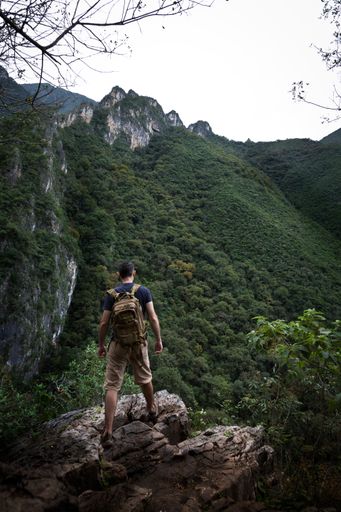 A vertical shot of a man observing the view standing in a rock in La Estanzuela Monterrey Natural Park in Mexico