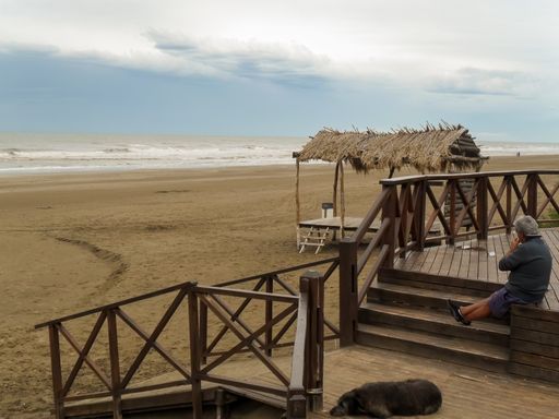 Mar de Ajo is a popular seaside summer vacation resort. In this shot, the beach, its wooden access and a coastal lifeguard cabin with hay roof.