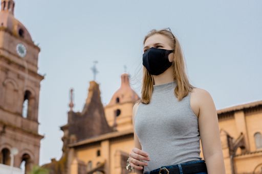 A low angle shot of a female wearing a facemask while walking outside