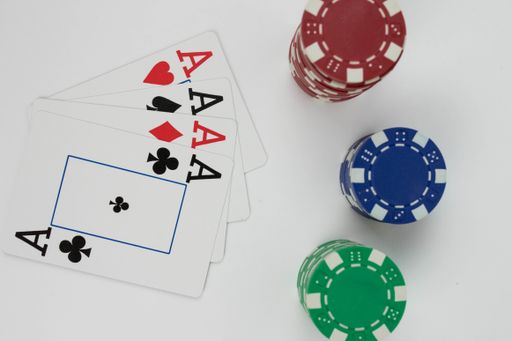 a top view of the playing ace cards and red blue green isolated poker chip stacks on a white background