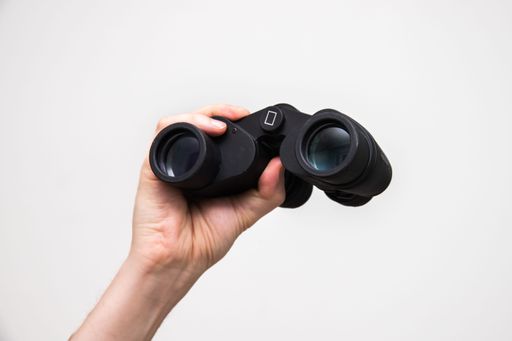 A closeup shot of the hand holding a binoculars