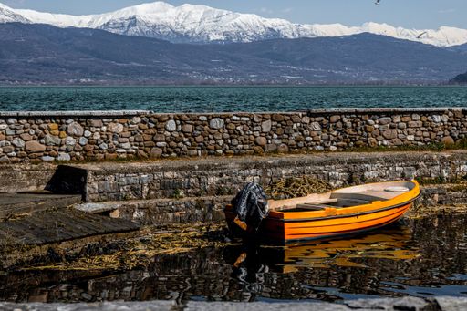 A wooden boat by the stone wall in a mountainous area
