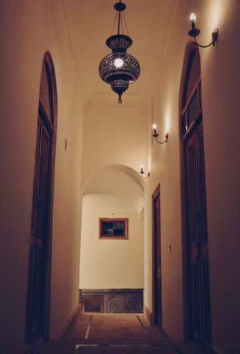 The brown doors in an apartment with a small chandelier.