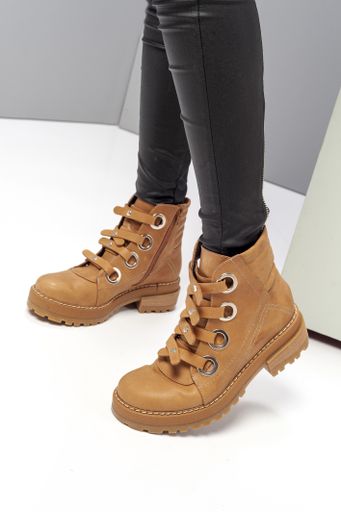 a vertical shot of female legs with black tight pants and brown boots
