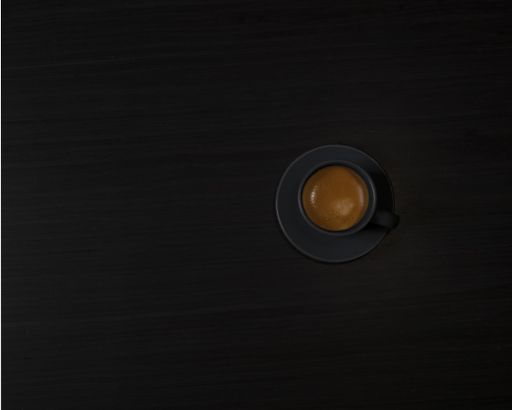 A high angle shot of a coffee cup isolated on a dark background