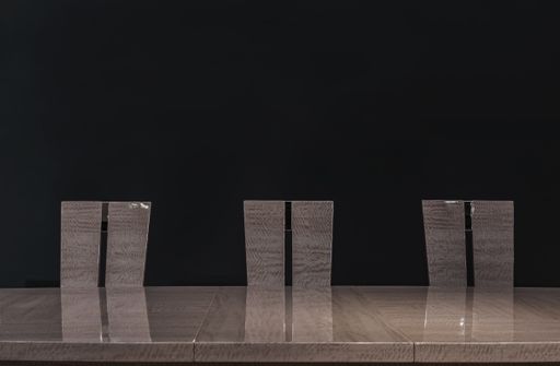 Brown dining table and three chair backs on a black background. Kitchen interier.