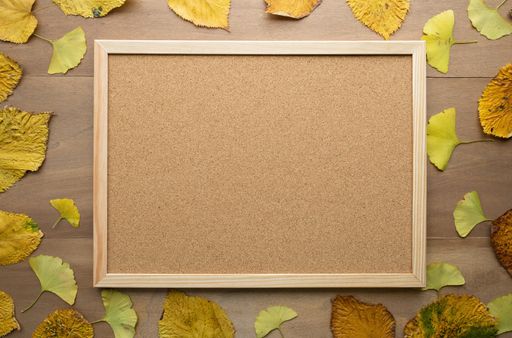 A wooden background with beautiful autumn leaves - space for text