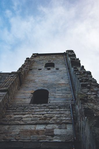 A vertical low angle shot of a damaged antique building