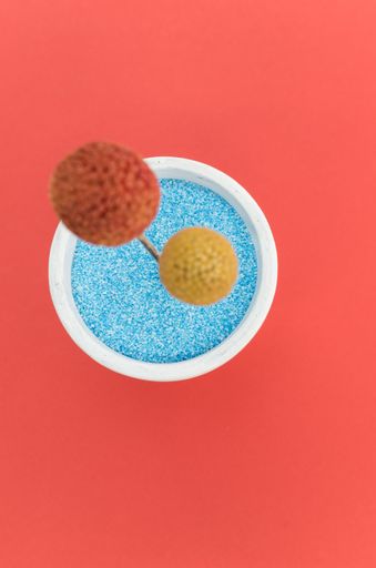 A vertical top view shot of an artificial flower on an isolated red background