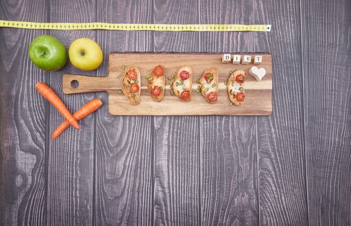 A flat lay of snacks on wooden board and vegetable on table