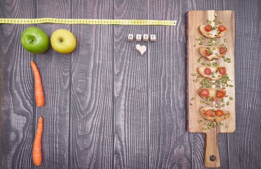A flat lay of snacks on wooden board and vegetable on table