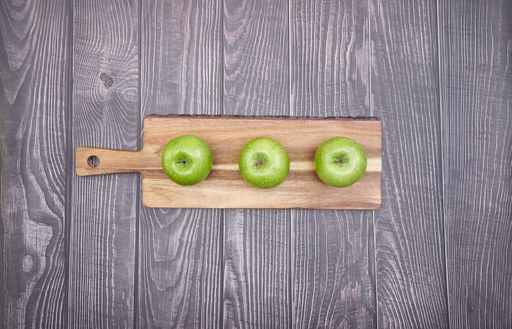 A top view of green apples on a wooden board