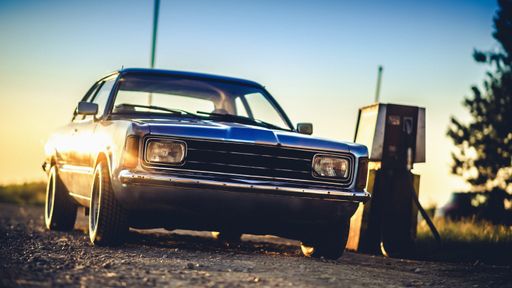 Old car at sunset on gas station