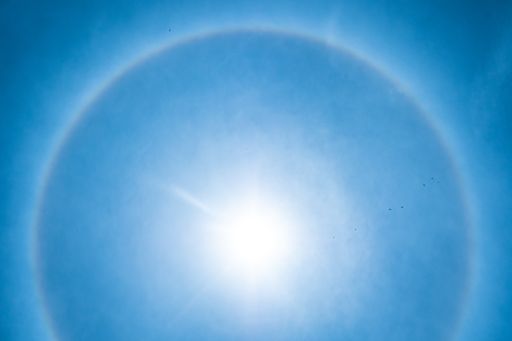 Solar Halo in a Blue Sky while Birds Fly in Medellin, Colombia