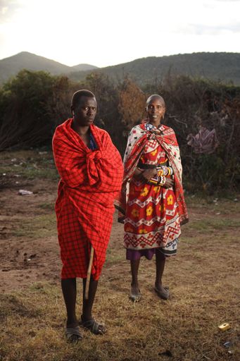 A vertical shot of an African couple standing near each other with an angry husband