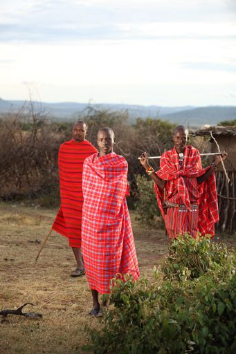 A vertical shot of African males with blankets around them while looking at the camera