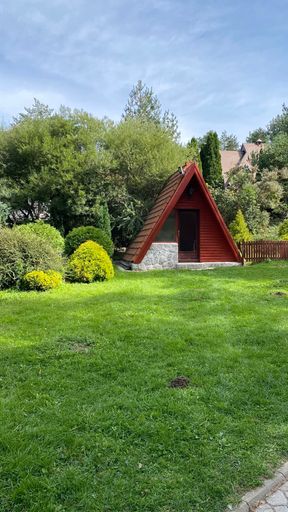 A rural house with green lawn and trees in the yard