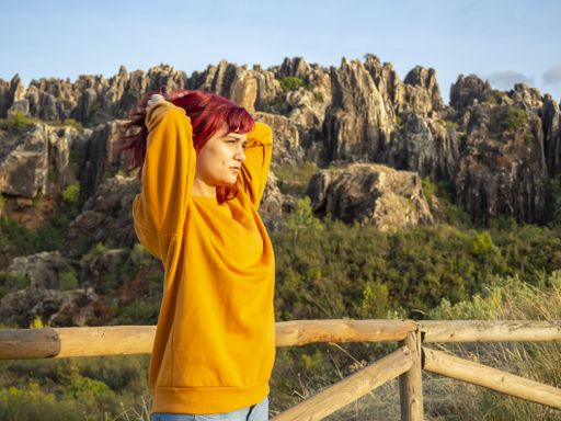 A closeup shot of a young attractive lady with red hair posing in Cerro del Hierro, Sevilla, Spain