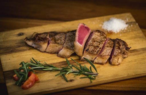 A delicious tasty dinner with red meat and vegetables on a wooden surface