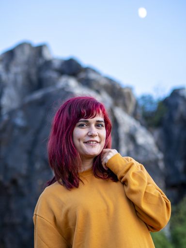 A vertical shot of an attractive lady with red hair posing in Cerro del Hierro, Sevilla, Spain