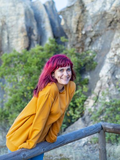 A vertical shot of a beautiful lady with red hair posing in Cerro del Hierro, Sevilla, Spain