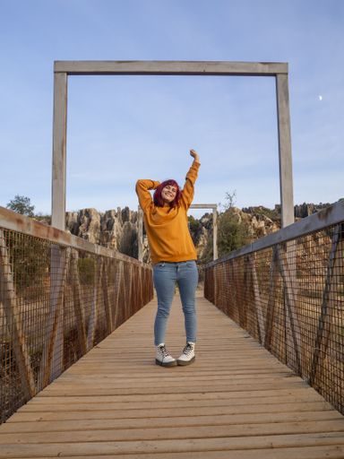 A vertical shot of a beautiful lady with red hair posing in Cerro del Hierro, Sevilla, Spain