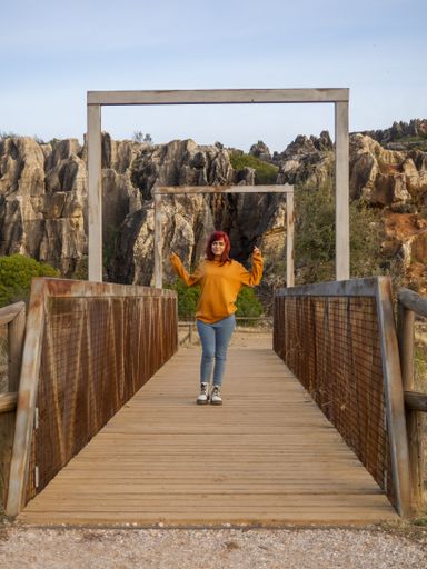 A vertical shot of a beautiful lady with red hair posing in Cerro del Hierro, Sevilla, Spain