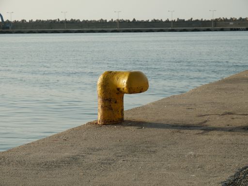 A yellow bollard on the pier