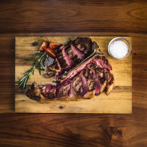 A delicious tasty dinner with red meat and vegetables on a wooden surface