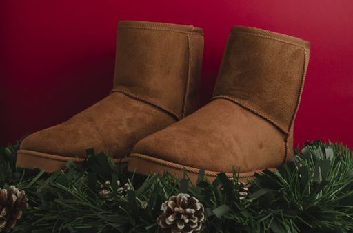 A pair of brown winter ugg boots on a red background