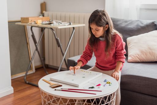 A Hispanic little girl doing art class at home - learning from home concept