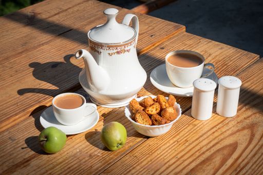 A closeup shot of tea time with snacks in white cutlery set in Manali, Himachal Pradesh