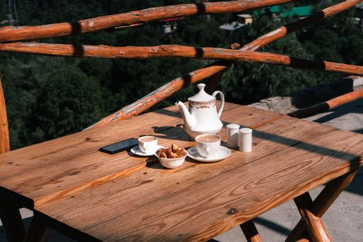 A closeup shot of tea time with snacks in white cutlery set in Manali, Himachal Pradesh