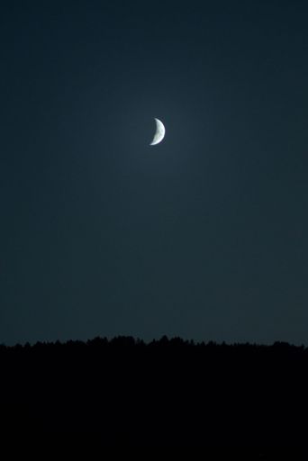 A vertical scenic shot of a crescent moon in the blue sky, backgrounds and wallpapers