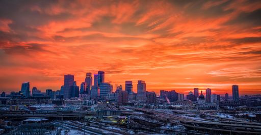 An aerial view of a beautiful skyline with modern buildings and a beautiful sunset in the background