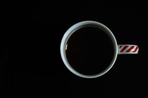 A top view of a cup of coffee on a black background