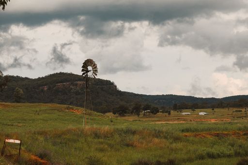 A closeup shot of a landscape and a windmill on a cloudy day