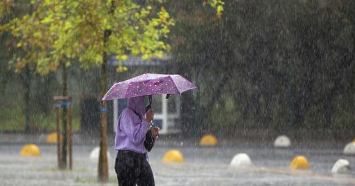 A selective focus shot of people with umbrella walking on a rainy day