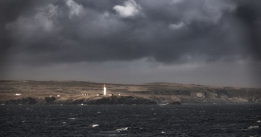 A gloomy scenery of the sea waves moving towards the direction of the wind after the rain