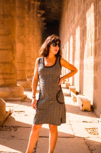 A vertical shot of a Caucasian woman in The Temple of Horus at Edfu, Egypt