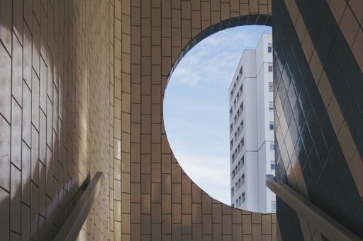 A white building visible from the round window in a tiled building