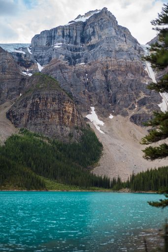 A vertical shot of rocky mountains behind the turquoise glacial lakes in Banff National Park, Alberta