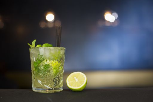 A closeup shot of a glass of mojito with mint leaves and lime