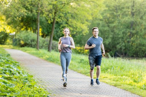 A young couple running in a forest and making fitness workout