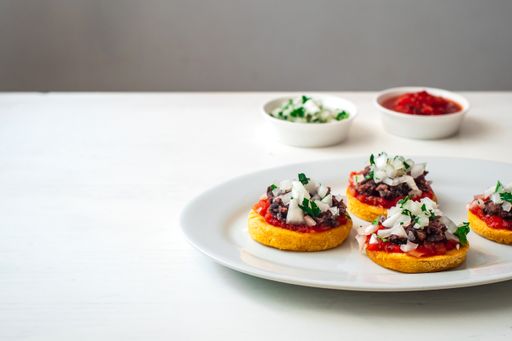 Sopes also known as Picadita, Traditional Mexican Dish That Looks like an Tortilla with Toppings like Tomato Sauce, Refried Beans, Raw Onion, Cilantro